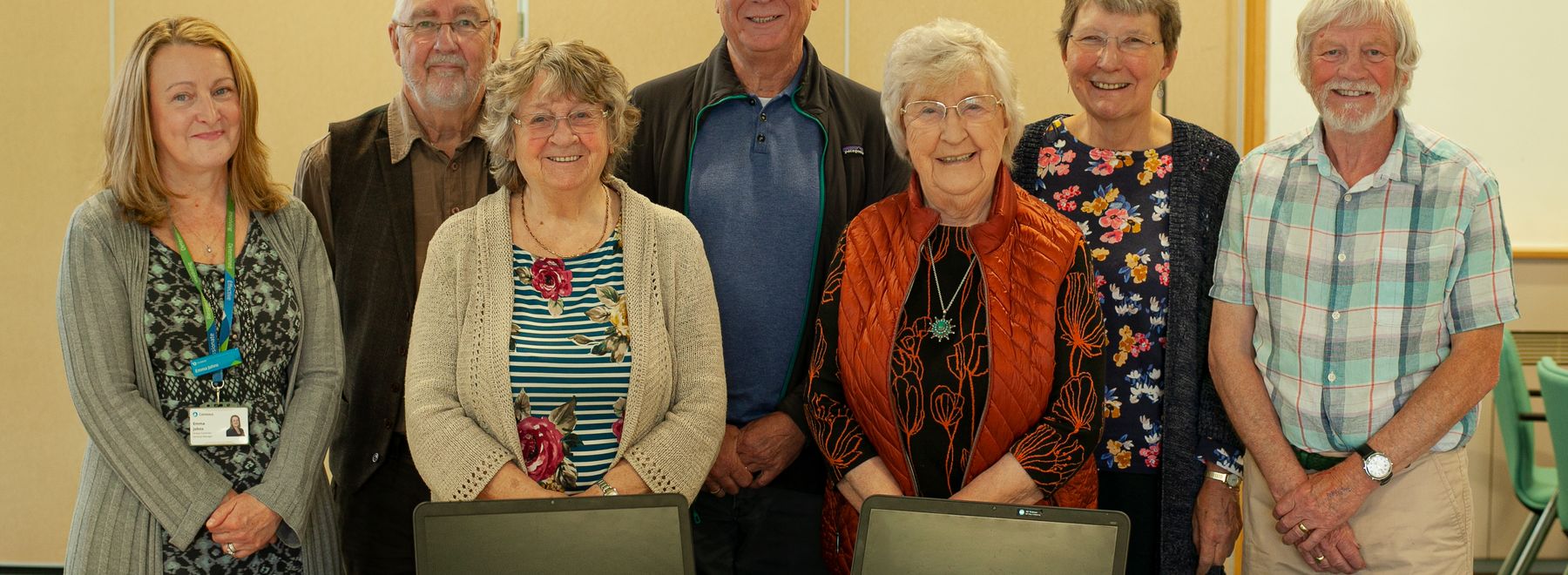 The GOAL group and Emma Johns from Connexus standing in front of two donated laptop computers 
