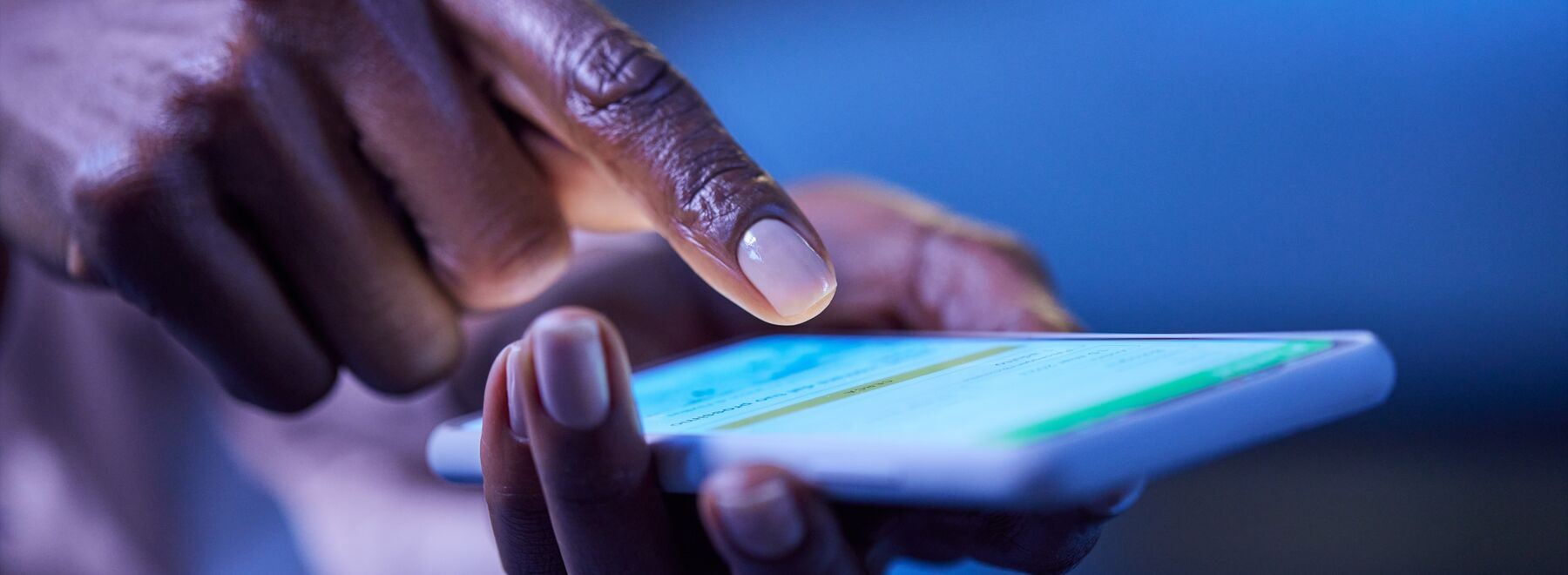 A hand holding a smartphone, with a finger about to press on the screen