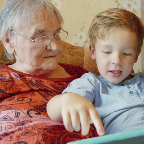 Grandparent and child learning on a digital tablet