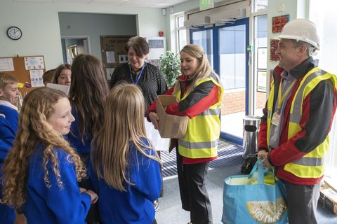 People in hi viz gear giving out gifts to schoolkids