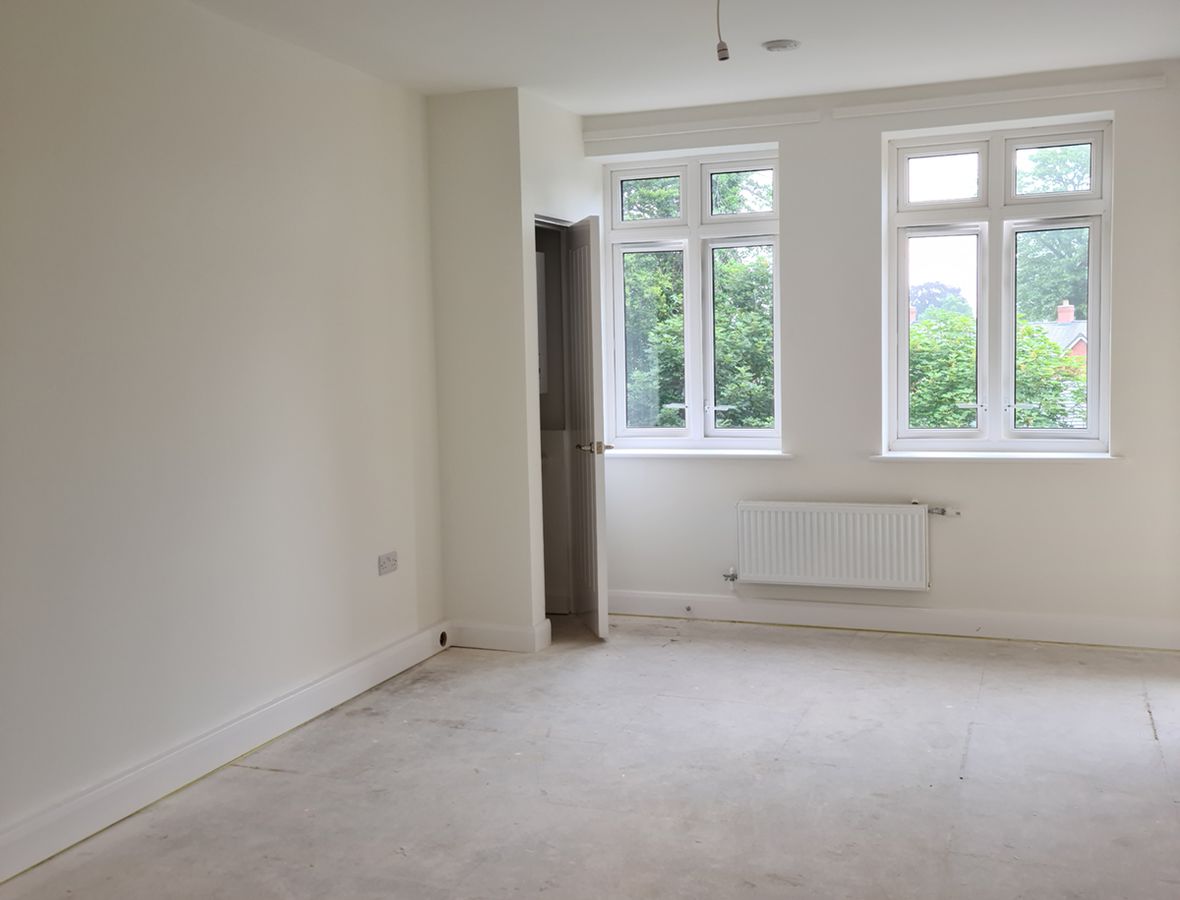 Living room with two windows and a door in the corner