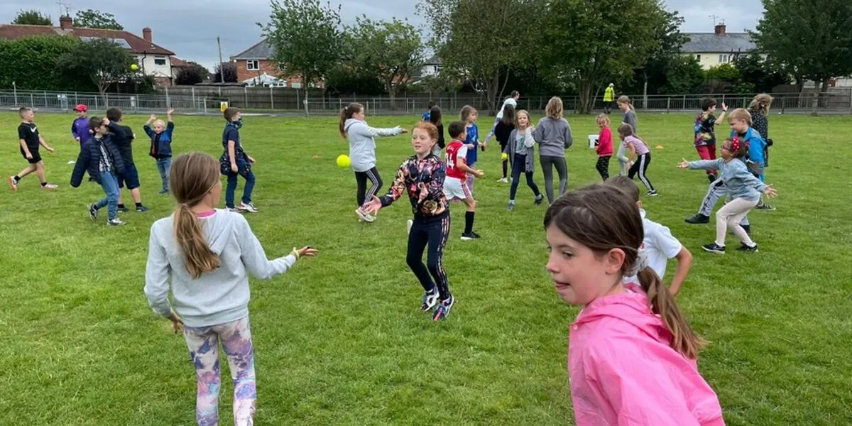 Children take part in summer activities on a field at New Saints FC