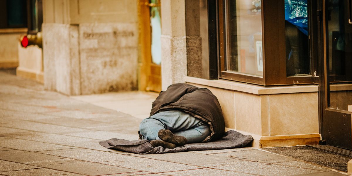 Man sleeping rough outside shop doorway