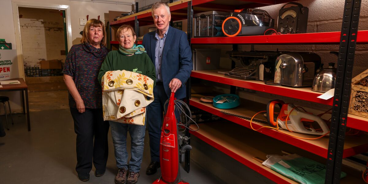 Connexus colleagues and workshop members pose in front of a shelving rack