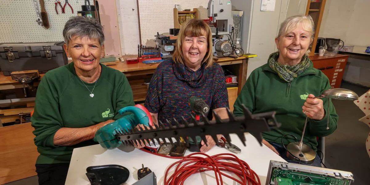 Connexus colleagues and workshop members pose with a mended hedge trimmer 