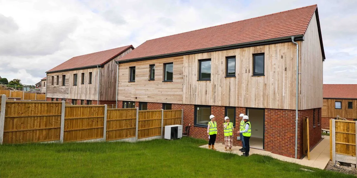 Three figures in the garden of one of the new homes