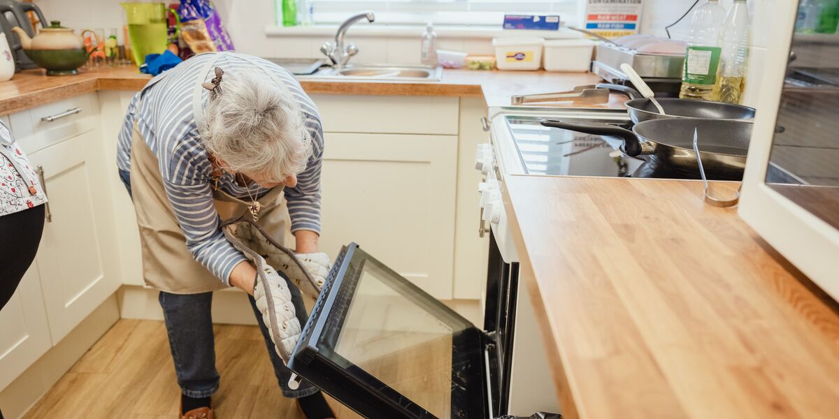 Someone bending down to look into an oven