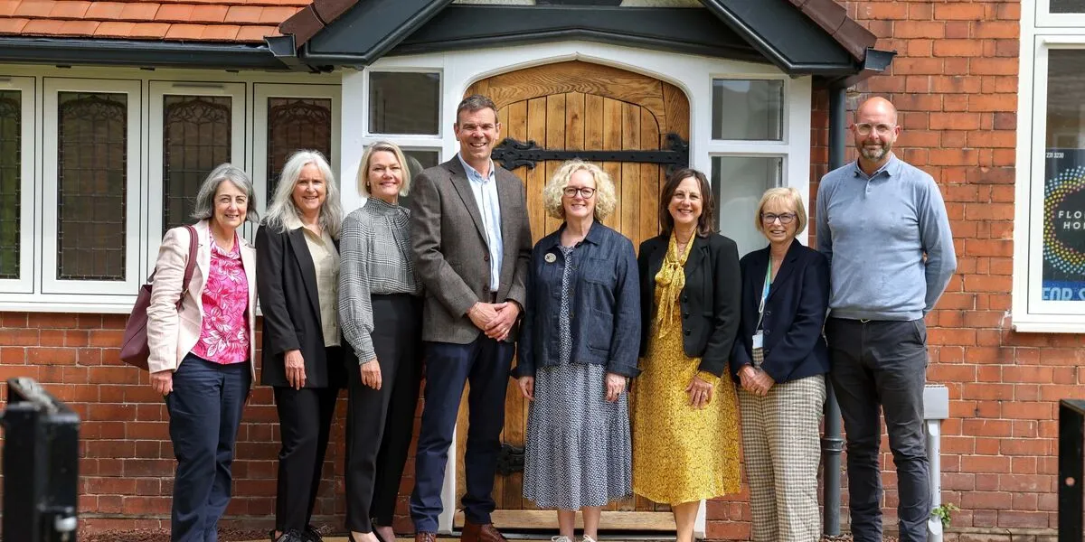 Cheerful people standing in front of a new house