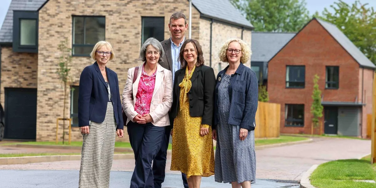 People standing in front of new houses