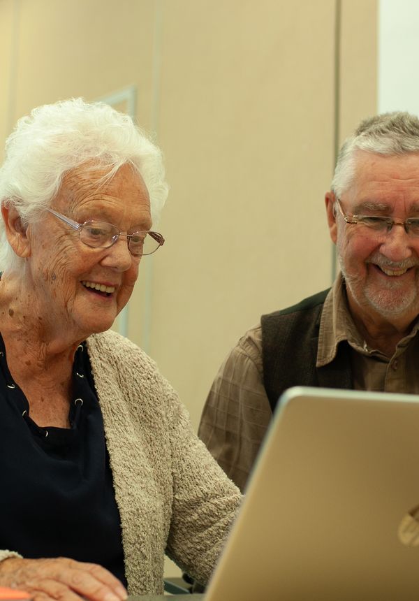 A learner from the GOAL group uses a laptop computer with guidance from one of the instructors. 