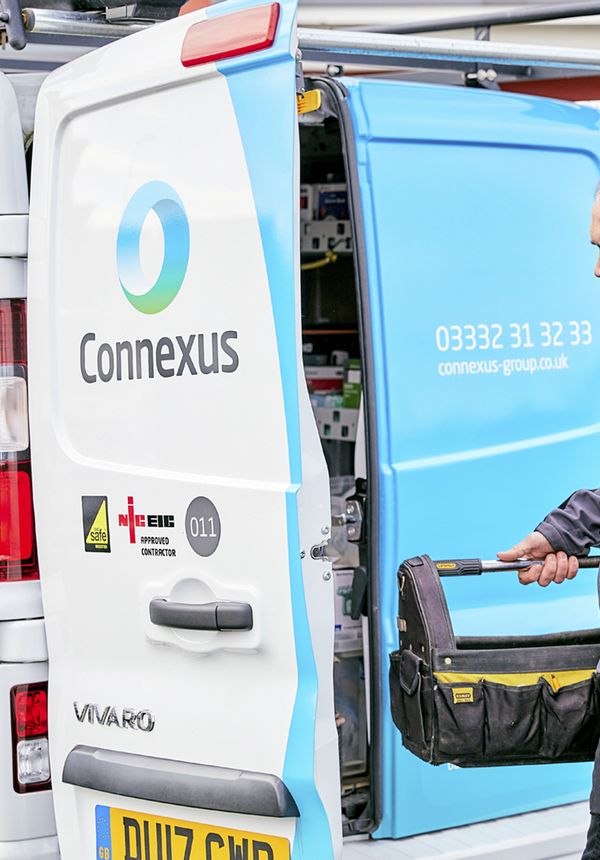 Connexus trades operative holding tool bag at the rear of a van