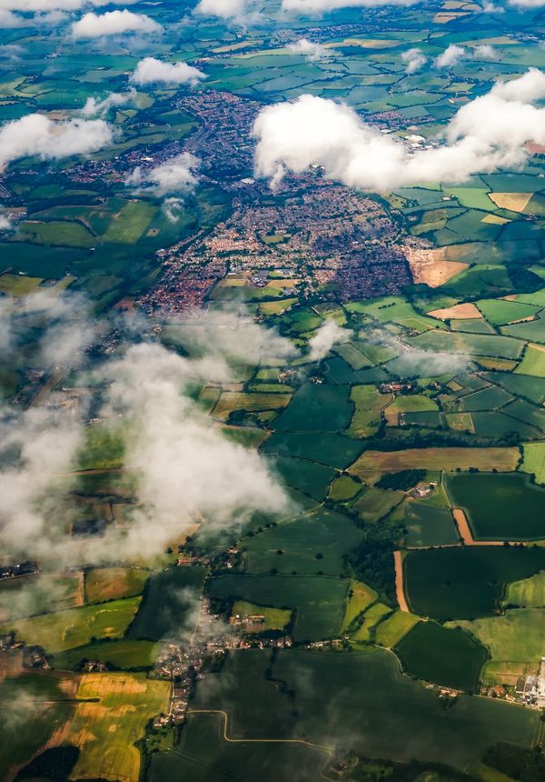 Aerial view of clouds, fields and small towns