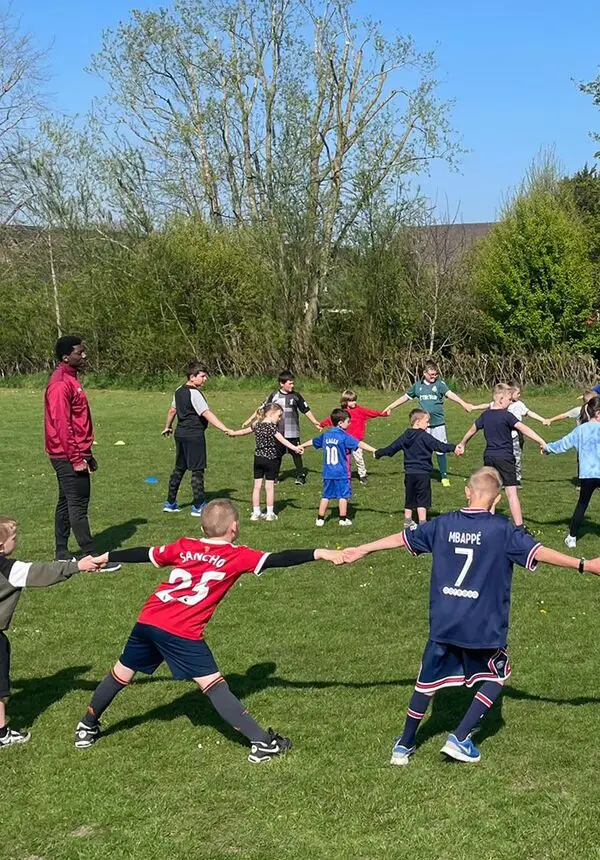 Coaches from The New Saints FC, Ellesmere, Shropshire, supervise children's outdoor activities