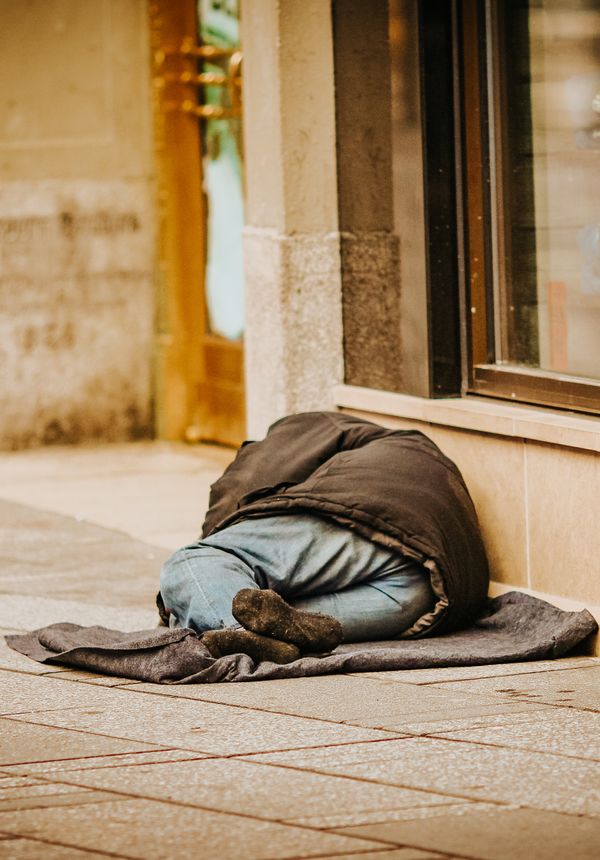 Man sleeping rough outside shop doorway