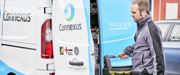 Connexus trades operative holding tool bag at the rear of a van