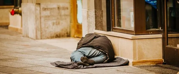 Man sleeping rough outside shop doorway