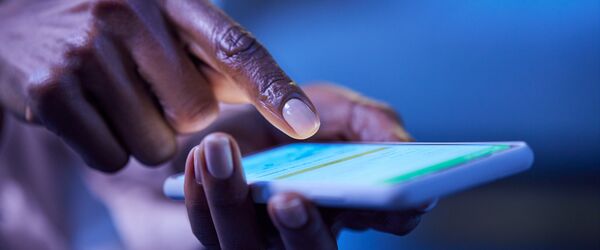 A hand holding a smartphone, with a finger about to press on the screen