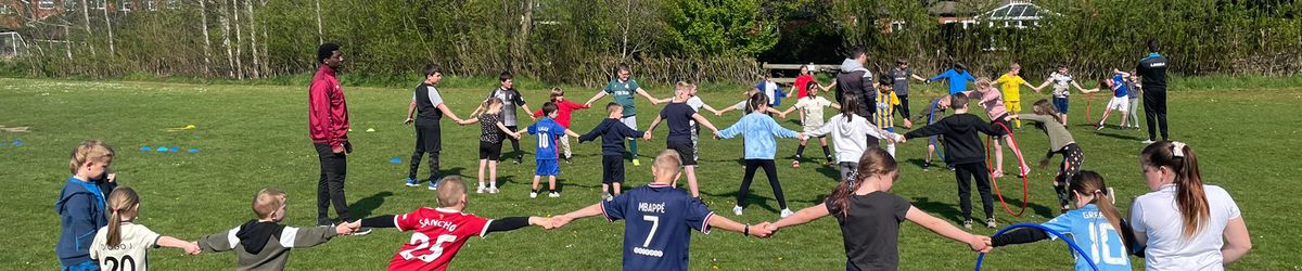 Coaches from The New Saints FC, Ellesmere, Shropshire, supervise children's outdoor activities