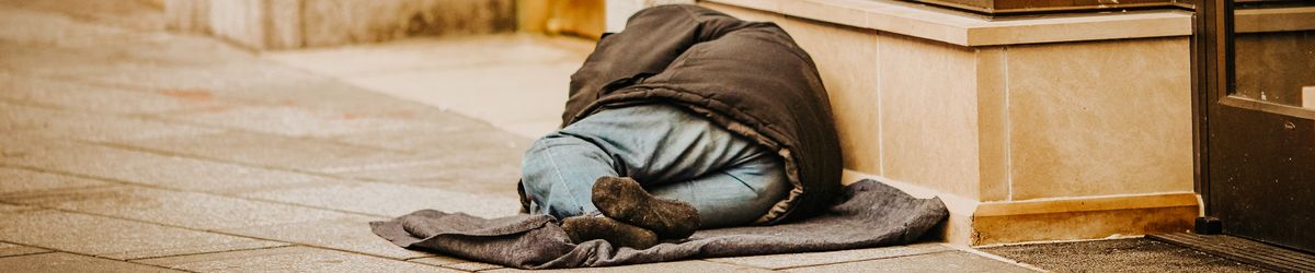 Man sleeping rough outside shop doorway