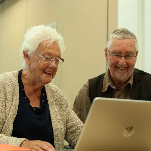 A learner from the GOAL group uses a laptop computer with guidance from one of the instructors.