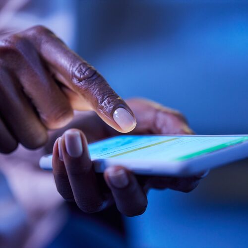 A hand holding a smartphone, with a finger about to press on the screen